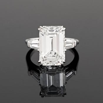 A platinum ring set with an emerald-cut diamond.