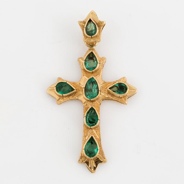 An 18K gold and emrald cross pendant.