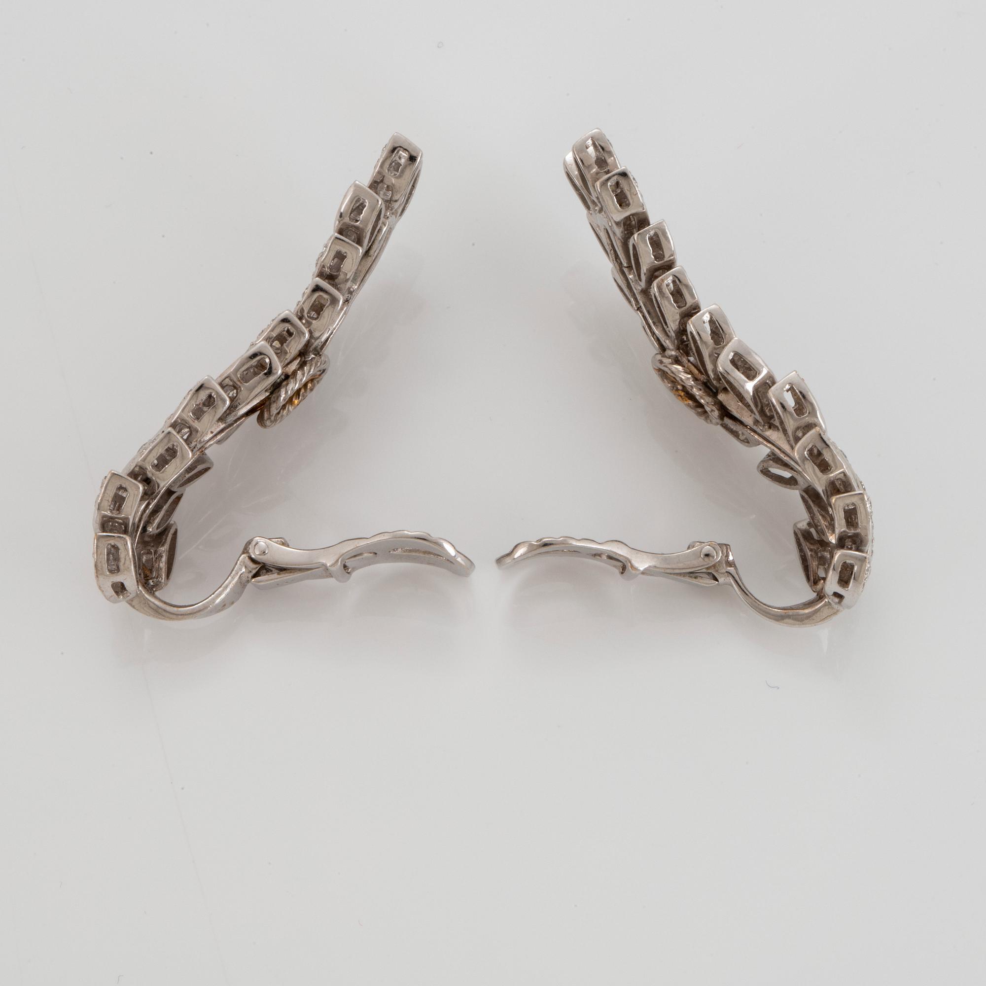 A pair of 18K white gold earrings set with round brilliant-cut diamonds.