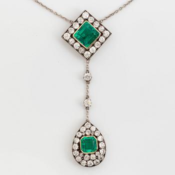 A necklace set with two faceted emeralds and old-cut diamonds.