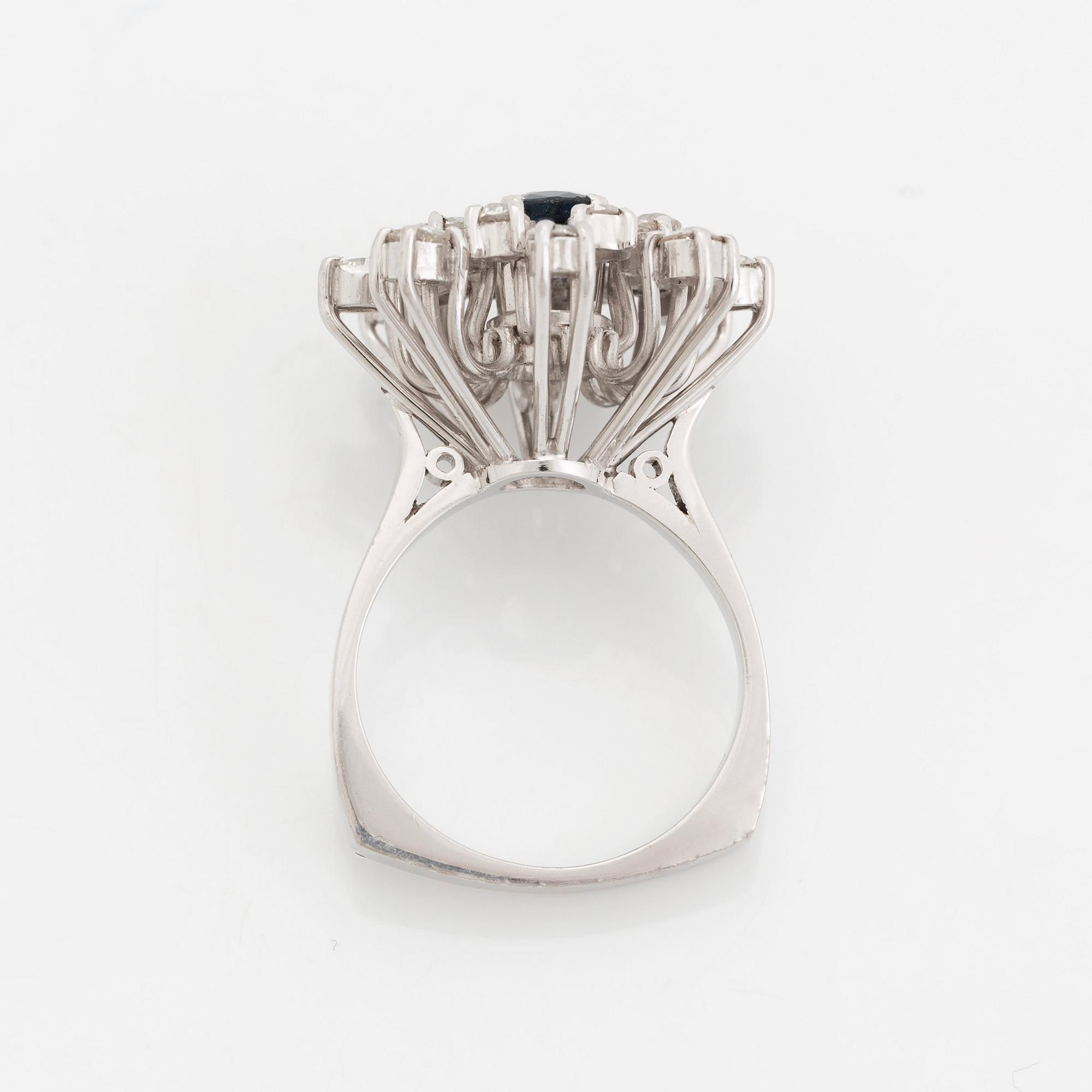 An 18K white gold ring set with a faceted sapphire and old-cut diamonds.