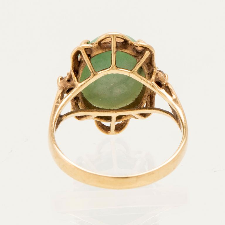 Ring in 14K gold with a green oval cabochon-cut stone and round brilliant-cut diamonds.