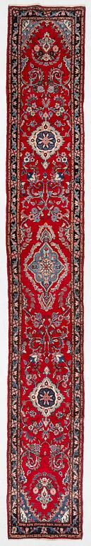 An oriental runner carpet, c. 550 x 75 cm.