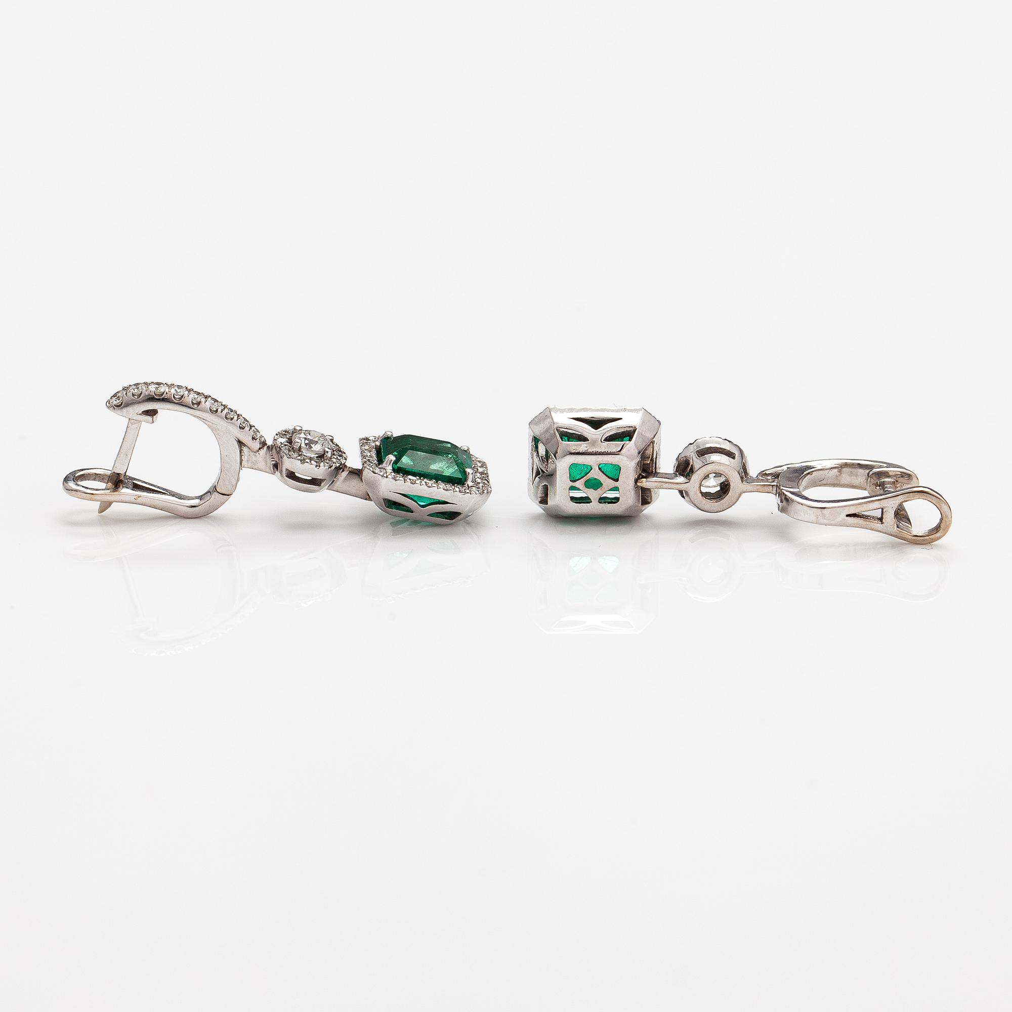 A pair of 18K white gold earrings with diamonds ca. 1.05 ct in total and emeralds ca. 4.20 ct in total. With certificate.