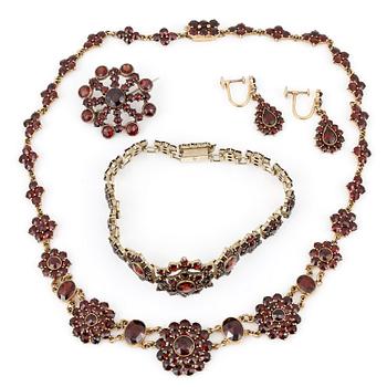 HALSBAND, ARMBAND, BROSCH samt ÖRHÄNGEN, ett par, med fasetterade granater, 1900-talets första kvartal.