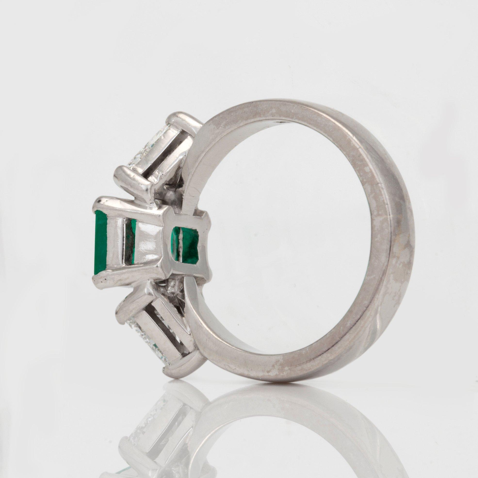 A circa 1.85ct emerald and trilliant-cut diamond ring.