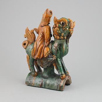 A Chinese sancai glazed stoneware roof tile in the form of a dignitary on a buddhist lion,  Mingdynasty (1368-1644).