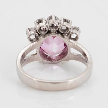 An 18K white gold ring set with a pink topaz and round brilliant-cut diamonds.