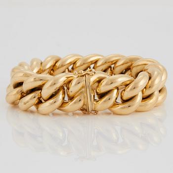 A curb link bracelet in 18K gold.