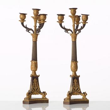 A pair of French Empire early 19th century gilt and patinated bronze four-light candelabra.