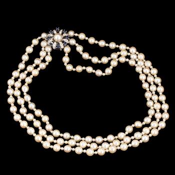 A necklace of baroque-shaped, cultured pearls with a clasp in 18K white gold decorated with diamonds and sapphires.