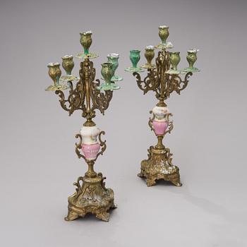 A pair of gilt-bronze Rococo Revival candelabra with porcelain decors, from the latter half of the 19th century.