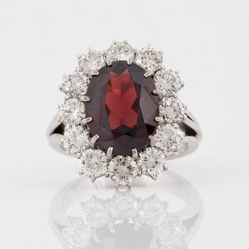 Ring, med ovalslipad granat ca 5.14 ct samt briljantslipade diamanter totalt ca 2.40 ct.