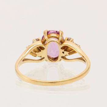 Ring 18K guld med oval fasetterad rosa ädelsten samt runda briljantslipade diamanter.