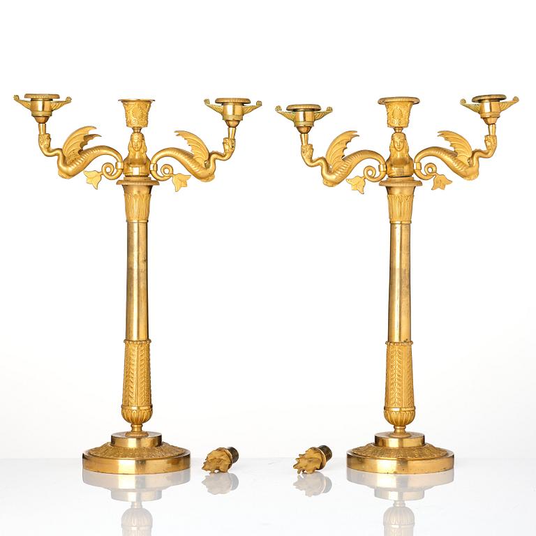 A pair of ormolu three-branch Empire candelabra, early 19th century.