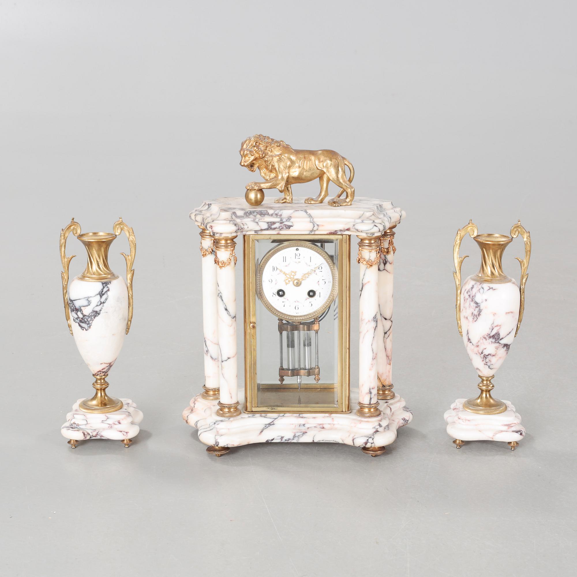 A Louis XVI style table clock and two urns, around the year 1900.