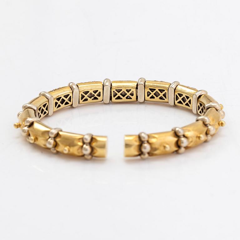 An ca. 18K gold bangle with diamonds approx. 0.50 ct. in total and rubies.