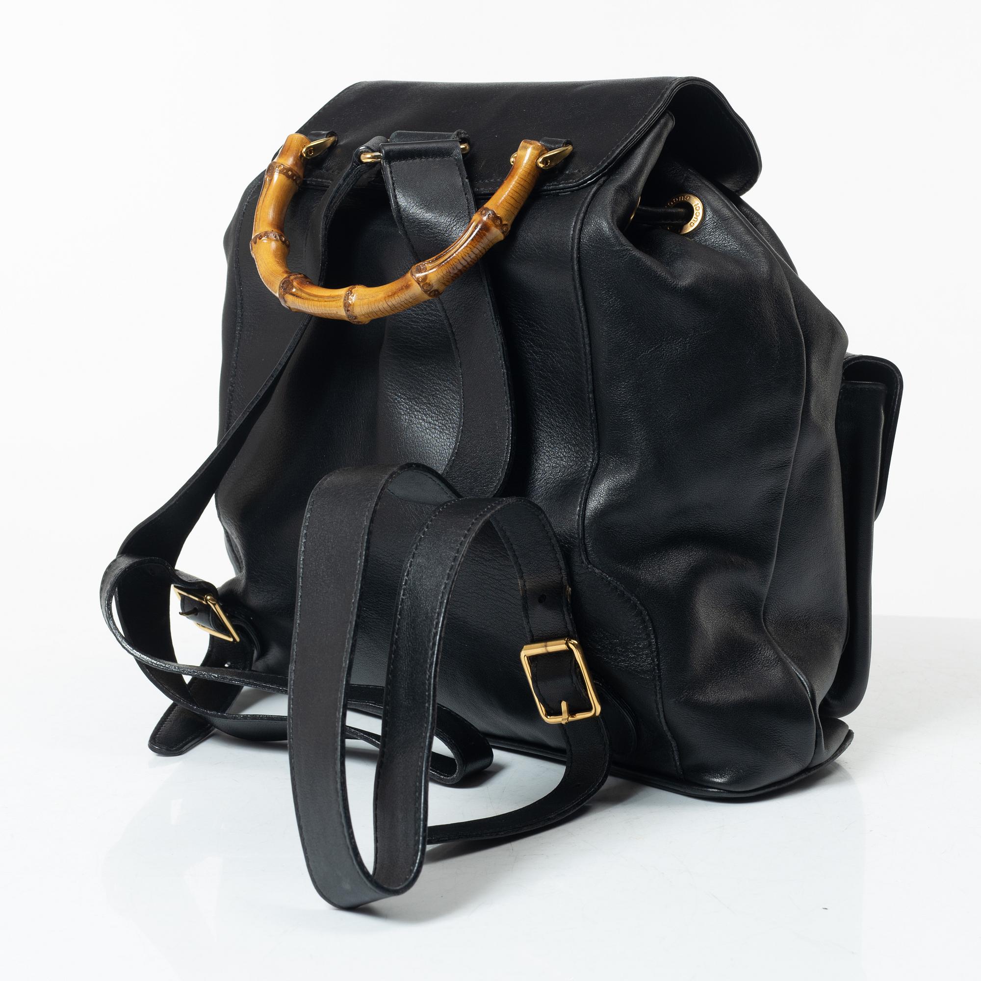 Gucci, A black leather backpack.