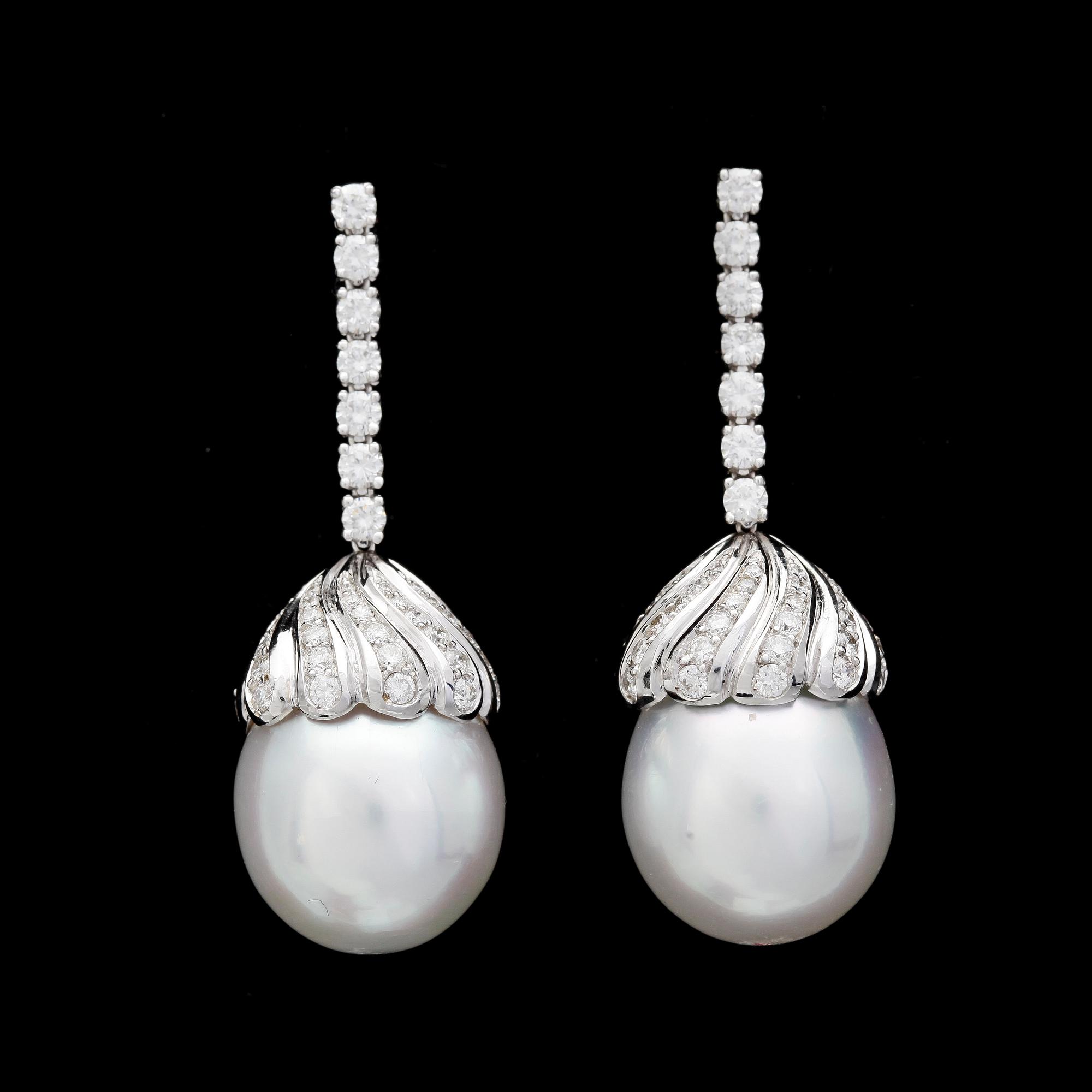ÖRHÄNGEN, odlade South sea pärlor, 14, 4 mm. med briljantslipade diamanter, tot. ca 1.45 ct.