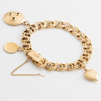 An 18K gold charm bracelet, one charm set with round brilliant-cut diamonds.