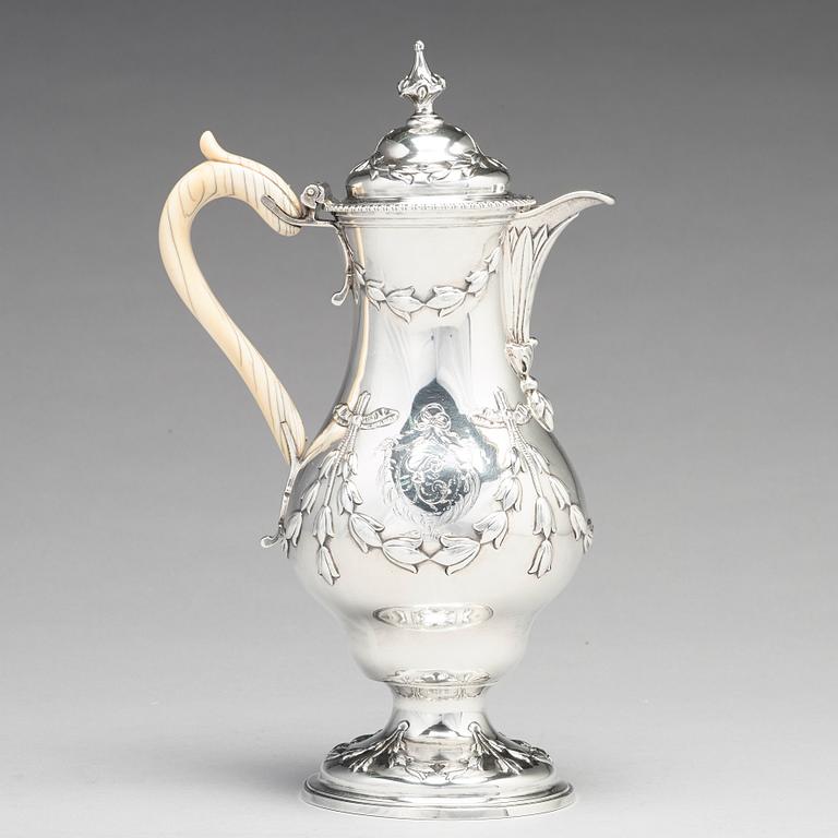 An English 18th century silver hot water-jug, mark of Chas Woodward, London 1773.