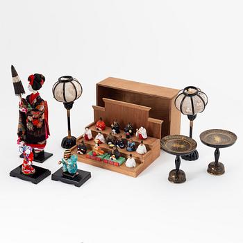 A group of Japanese dolls and lacquered miniature furniture in wooden crates, early 20th Century.