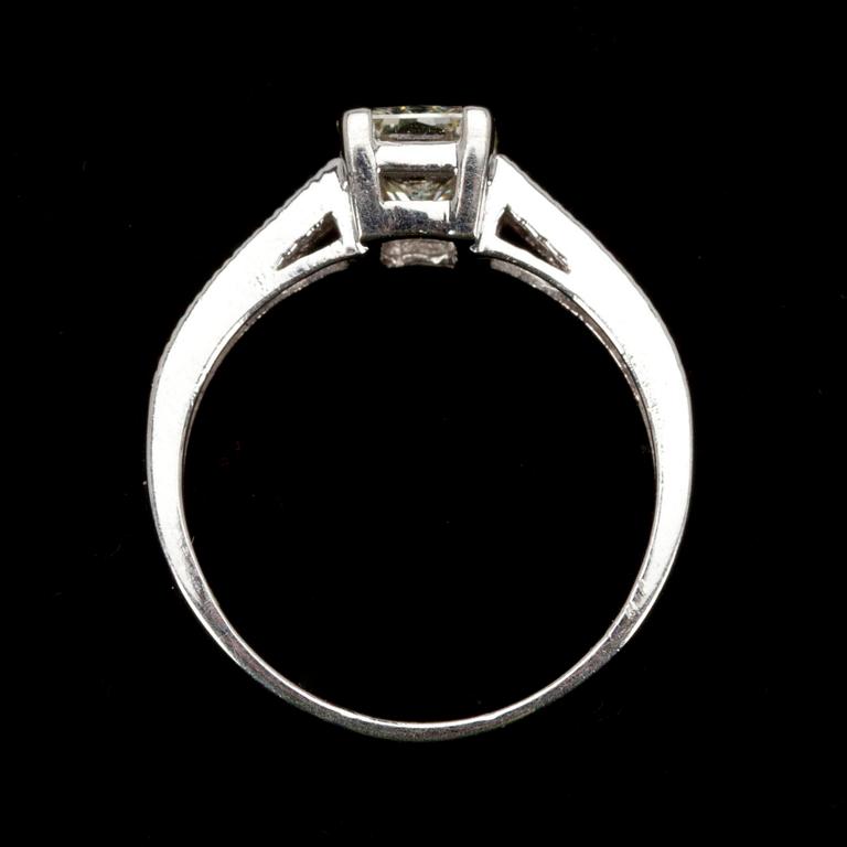 RING, vitguld 14K, mittsten 1,25 ct, sidostenar 10 st. tot. 0,15 ct. Vikt 2,9 g. Intyg.