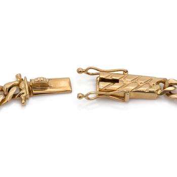 An 18K gold curb-link bracelet and a charm.