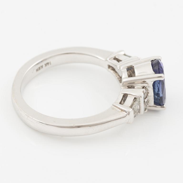 Ring in 14K gold set with a faceted tanzanite and diamonds in various cuts.