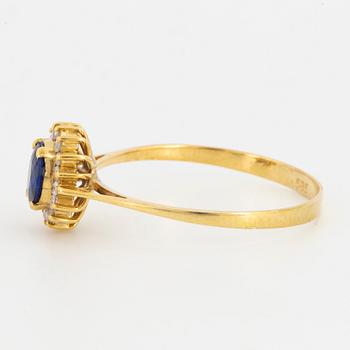 Oval mixed-cut sapphire and round brilliant-cut diamond halo ring.