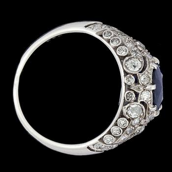 RING, oval blå fasettslipad safir med åttkantslipade diamanter. Art Deco, ca 1925.