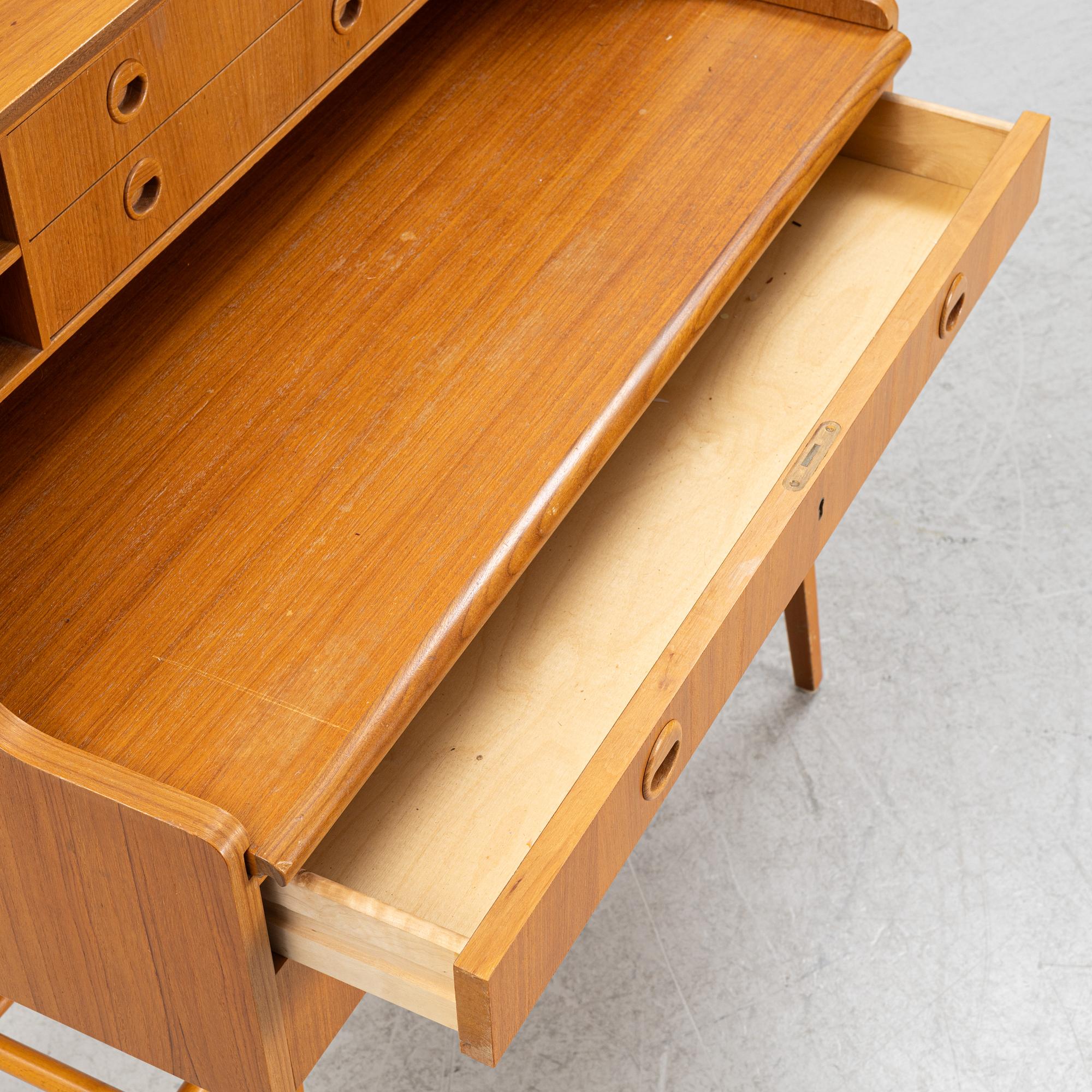 A teak-veneered desk, mid 20th century.
