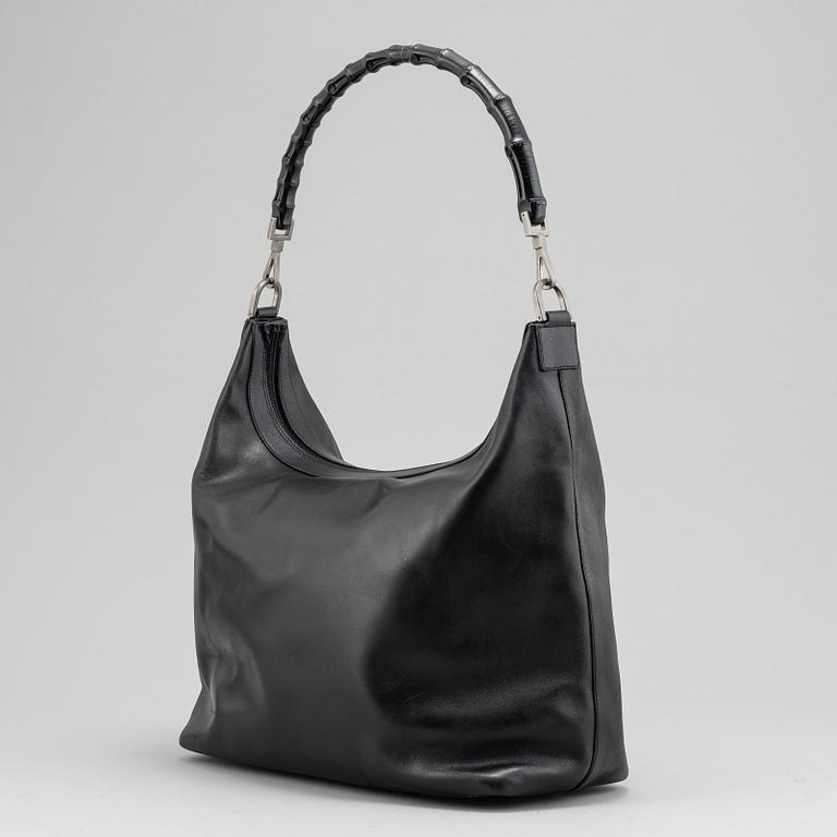 Gucci, a black leather handbag.