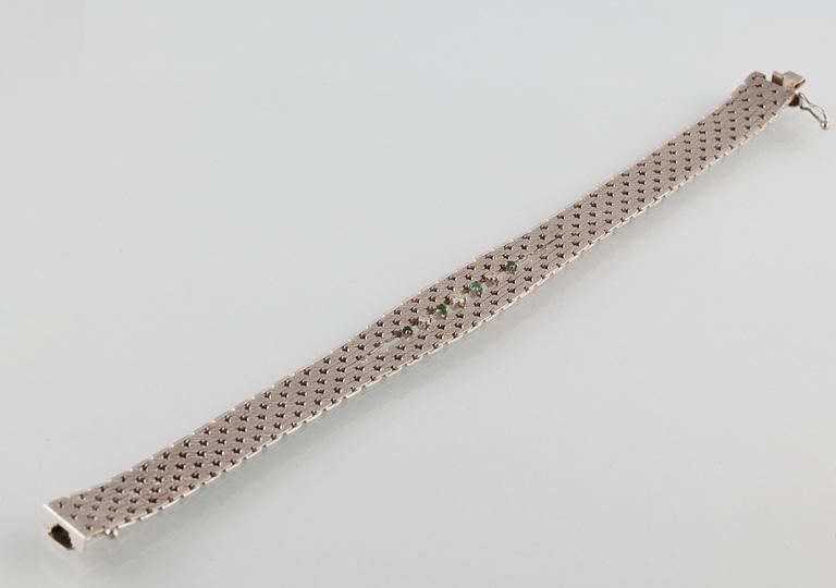 ARMBAND, 18K vitguld med en briljantslipad och 2 åttkantslipade diamanter samt 4 fasettslipade smaragder. Vikt 35,5 gram.