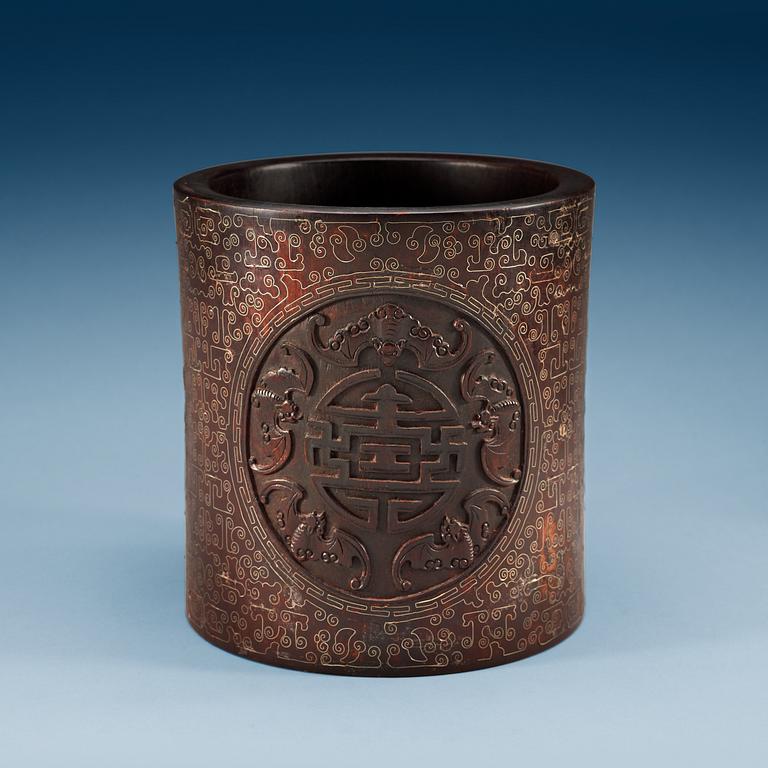 A carved wooden brush pot with metal inlay, Qing dynasty.