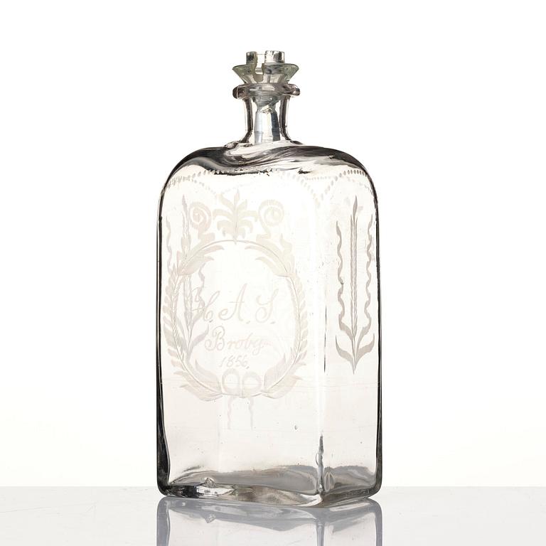 Brännvinsflaska, glas. Daterad Broby 1856.