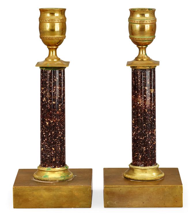 A pair of late Gustavian early 19th century gilt bronze and porphyry candlesticks.