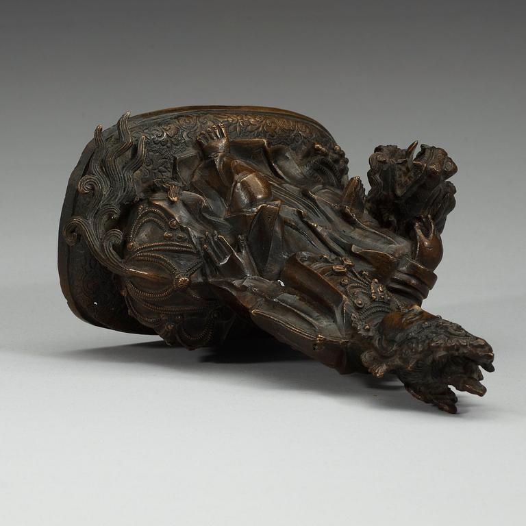A bronze figure of Guanyin seated on a mythical beast, presumably Qing dynasty.