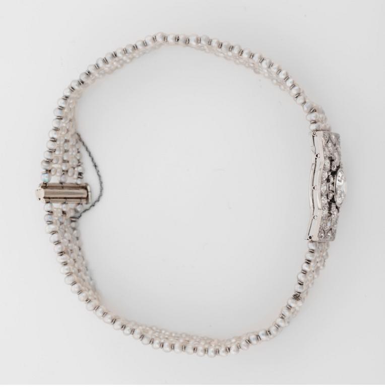 ARMBAND med gammalslipad diamant ca 0.90 ct, orientaliska pärlor samt mindre diamanter, totalt ca 1.00 ct. Ca. 1920-tal.