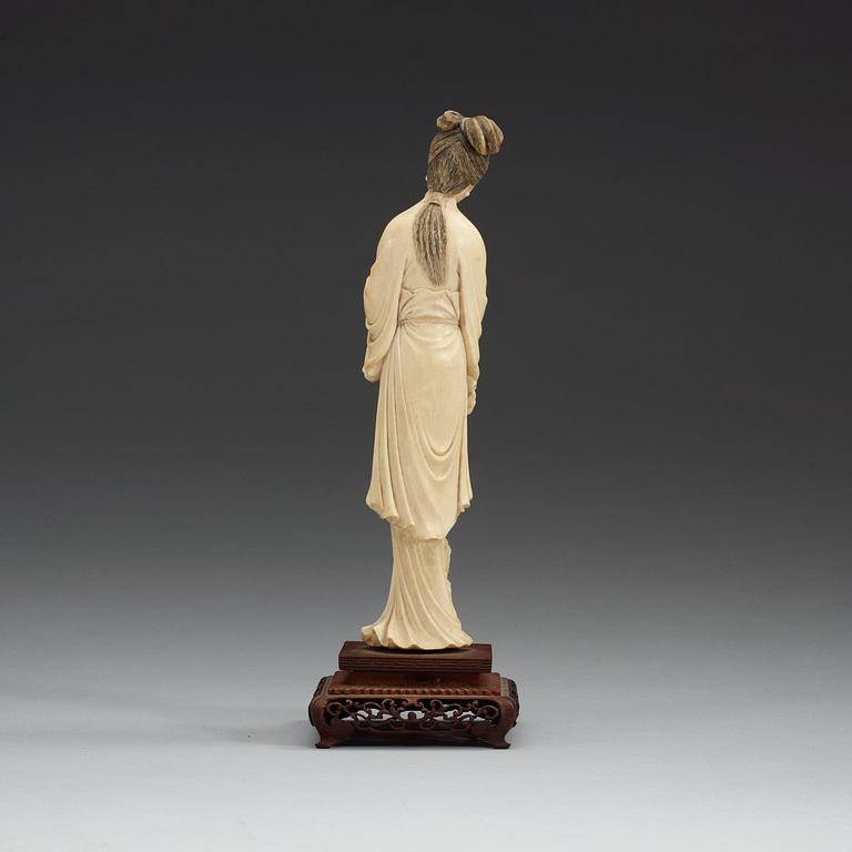 A carved ivory figure of an elegant lady and her dog, Qing dynasty (1644-1912).