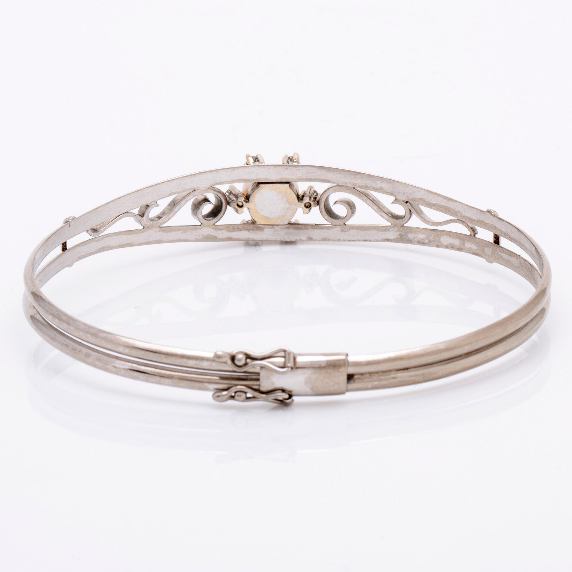 Armring 18K vitguld 1 odlad pärla ca 7,5 mm och 6 diamanter 8/8, stämplad K HIL Helge Larsson Malmö 1966, ca 16 cm.