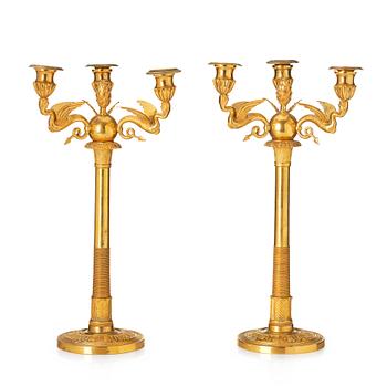 A pair of three-branch Empire-style ormolu candelabra, 19th century.