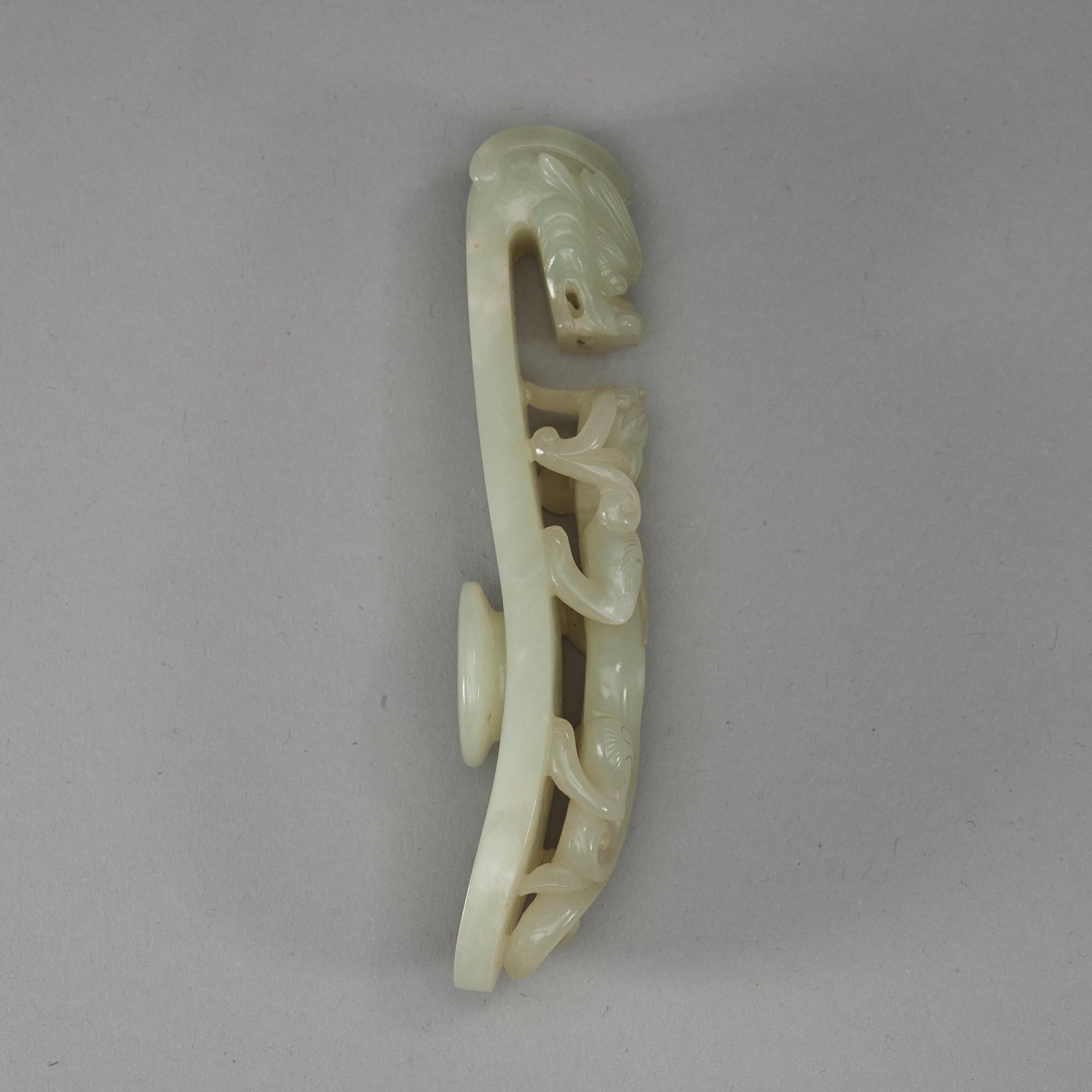 A pale celadon carved nephrite belt hook, Qing dynasty (1644-1912).