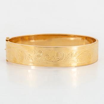 An 18K gold bangle.