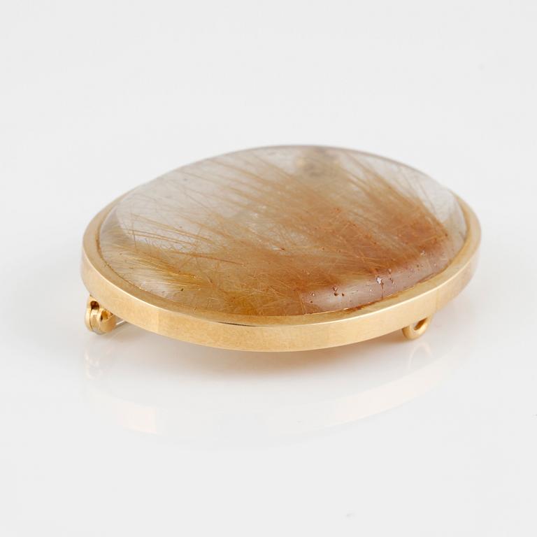 BROSCH, 18K guld med cabochonslipad rutilkvarts. Vikt 17,5 gram.