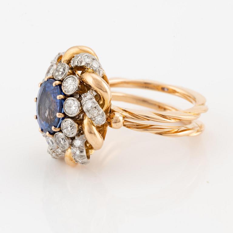 An 18K gold  ring with a sapphire and round brilliant-cut diamonds.