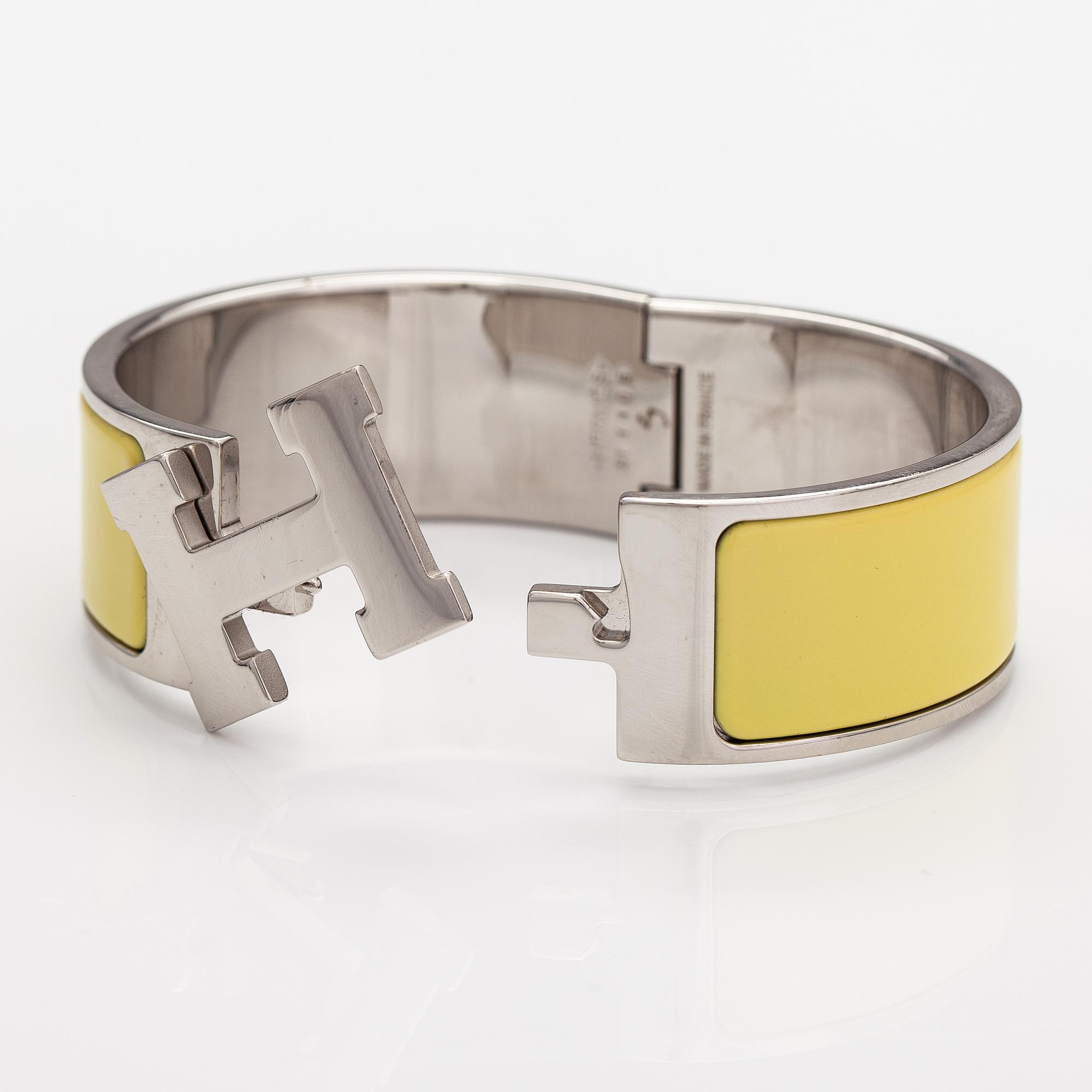 Hermès, A "Click H" bracelet made of metal and yellow enamel. Marked Hermès, ST1105, S, Made in France.
