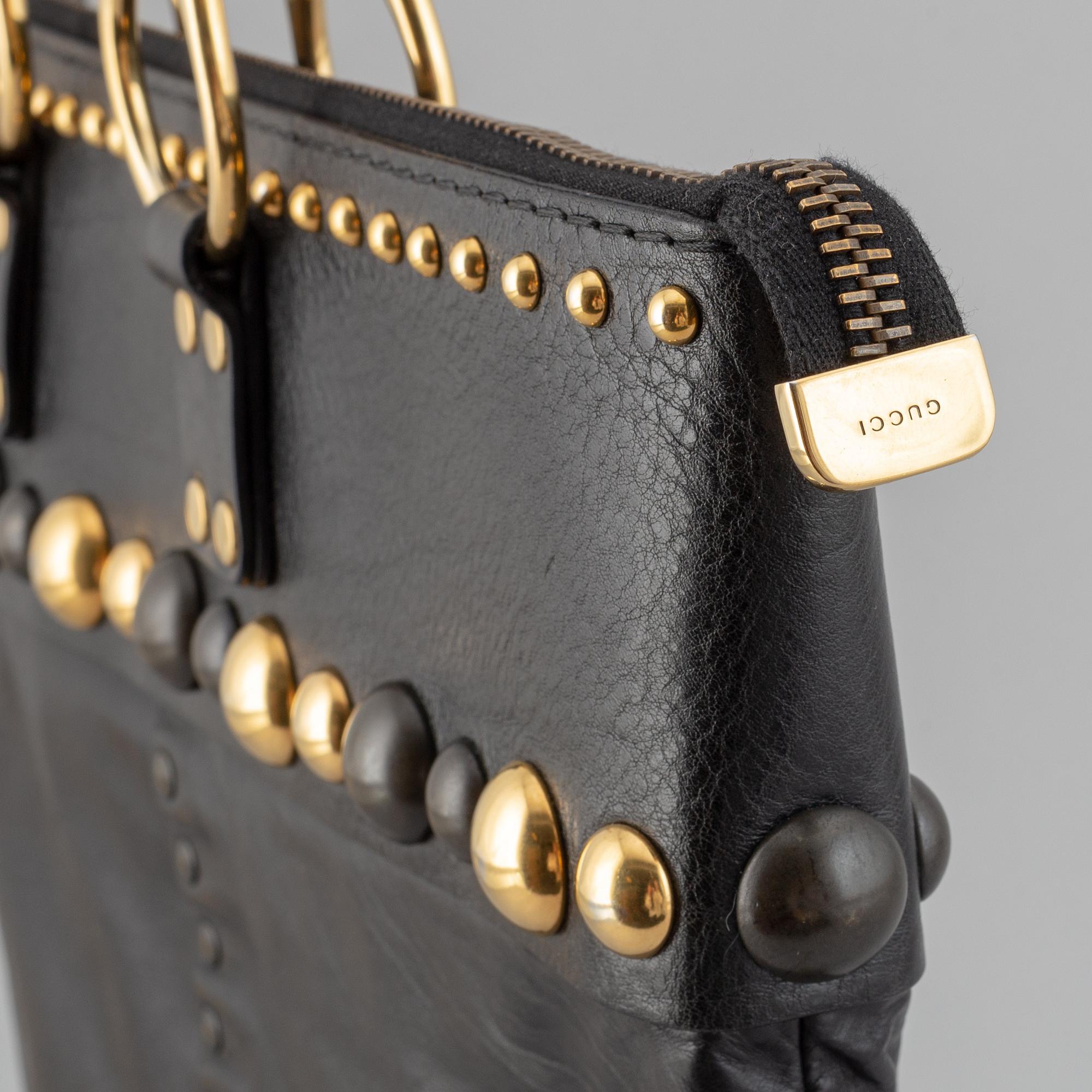 Gucci, a black leather handbag.