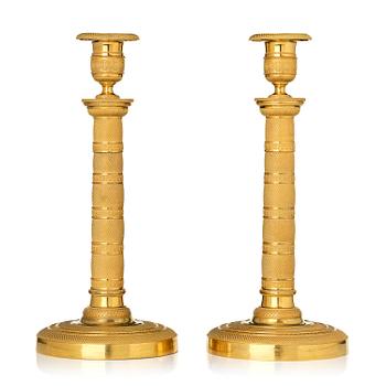 174. A pair of French Empire gilt-bronze candlesticks, early 19th century.
