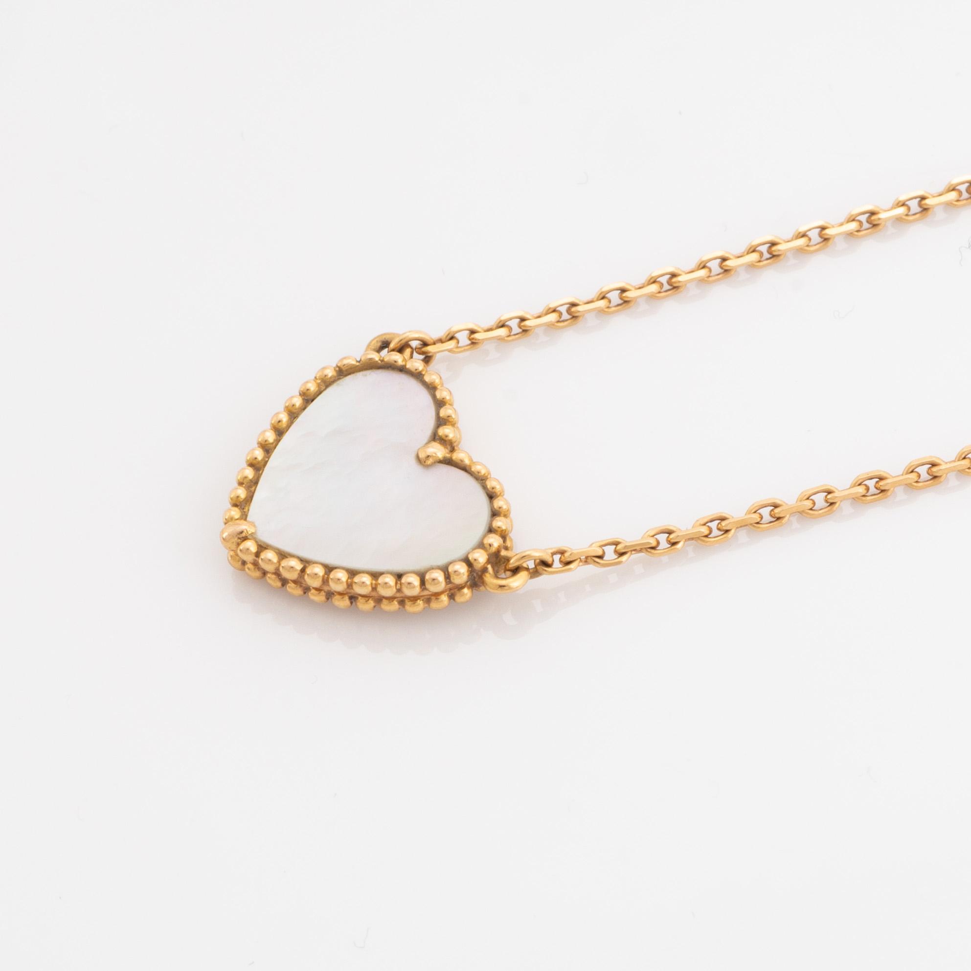 Van Cleef & Arpels, 18K gold and mother of pearl Alhambra heart necklace.